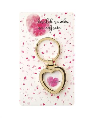 Brelok - amulet na zdjęcie z hasłem Kocham. Wydawca: Jawi. SmakLiter.pl Opakowanie Brelok - amulet na zdjęcie z hasłem Kocham