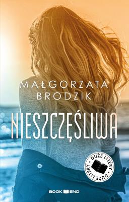 Nieszczęśliwa. Duże Litery. Autor: Małorzata Brodzik. SmakLiter.pl Okładka książki Nieszczęśliwa. Duże Litery